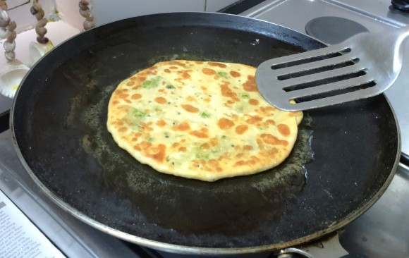 pouring ghee on the paratha