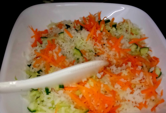 mixing poha with cucumber and carrot