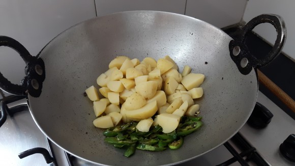 Add curry leaves, green chili, chopped potatoes 