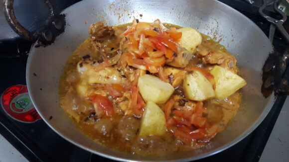 add chopped tomato, turmeric powder, coriander powder, chili flakes, fried potatoes