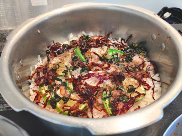 spread another half fried onion, green chili Julian, mint leaves and lemon slices.