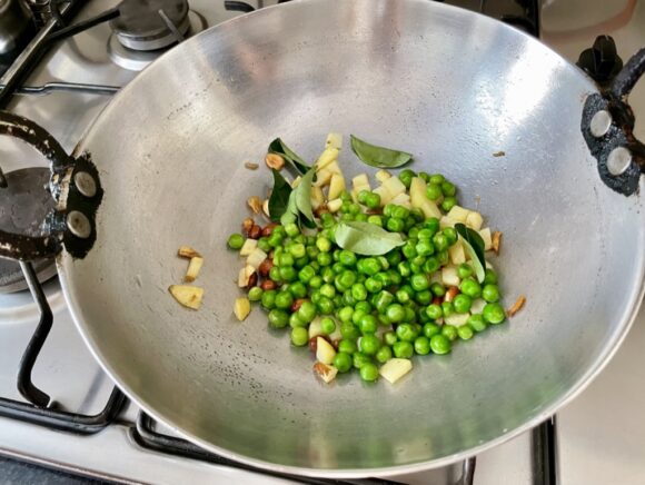 add peas, slitted chilli and curry leaves