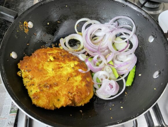 spread onion rings  and green chilli on the pan