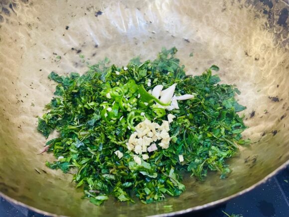 put bathua saag, chopped green chilli, ginger and half quantity of garlic