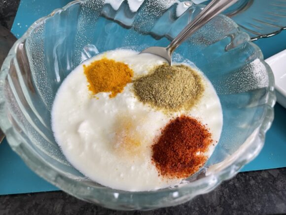 put curd, turmeric powder, red chilli powder, coriander powder and salt