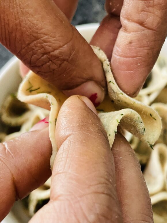 fold the edges of small chapati from three sides and press little into centre