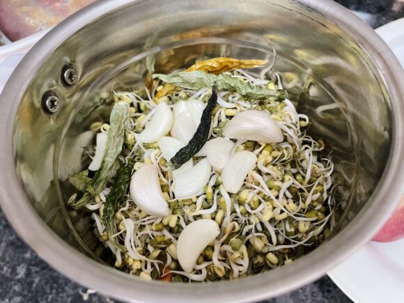 Roughly grind mung sprout along with green chilli and garlic