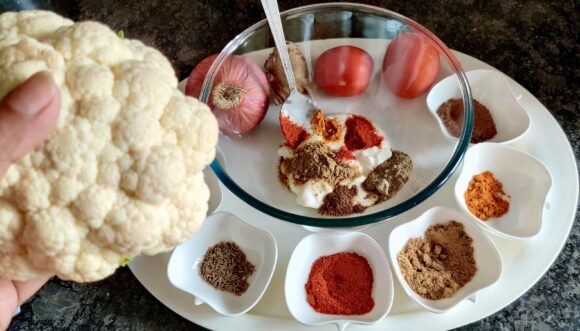 Marinate the cauliflower with mixture of yogurt, ginger paste, salt, chat masala, chilli powder, turmeric powder, coriander powder 