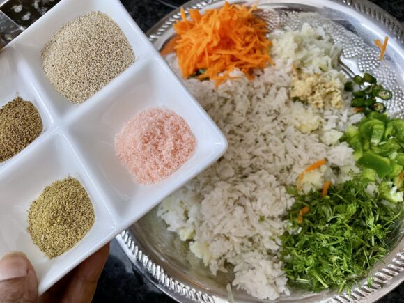 put soaked poha, chopped coriander, grated potato, carrot, chopped bell peppers, green chilli, ginger, fried onion, all powder masala, corn flour and salt.